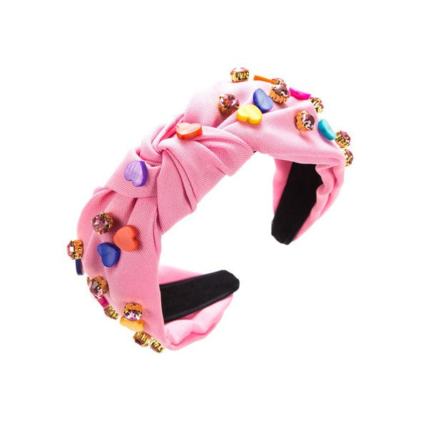 Pink headband with colorful embellishments on a white background