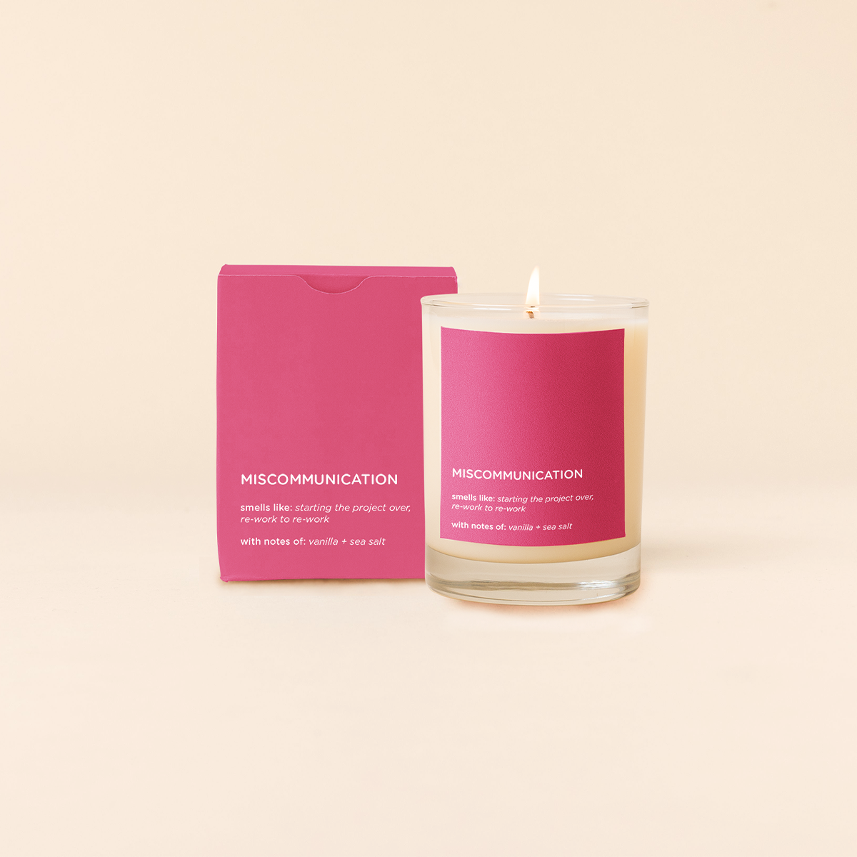 Candle with pink packaging labeled 'Miscommunication' on a beige background