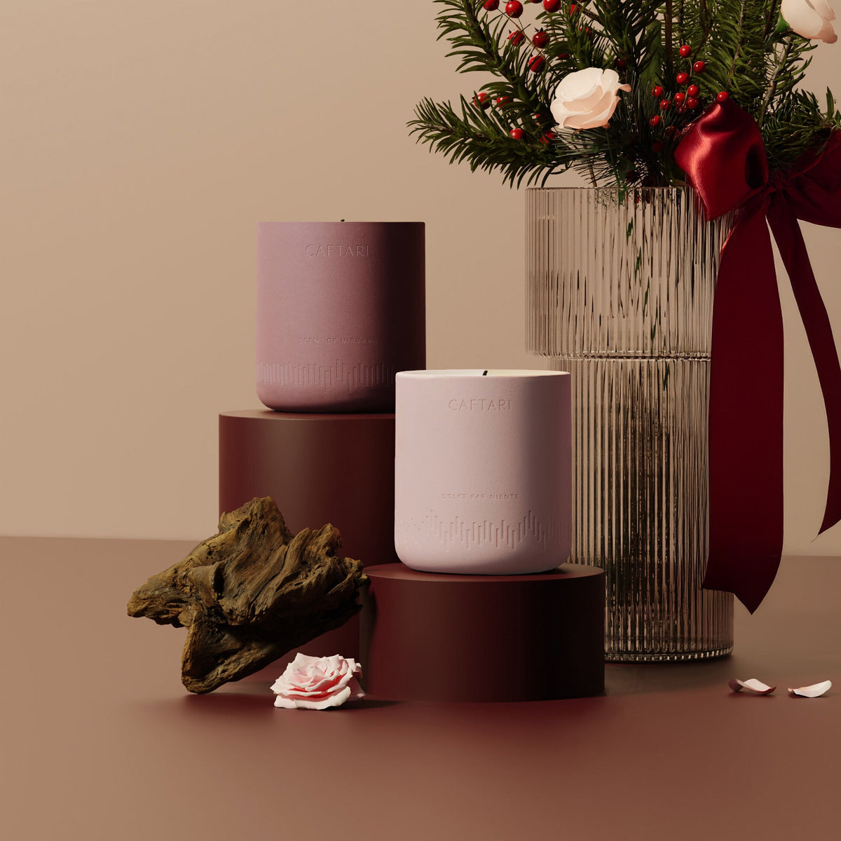 Two caftari luxurios candles on stands with a vase of flowers and decorative elements on a beige background