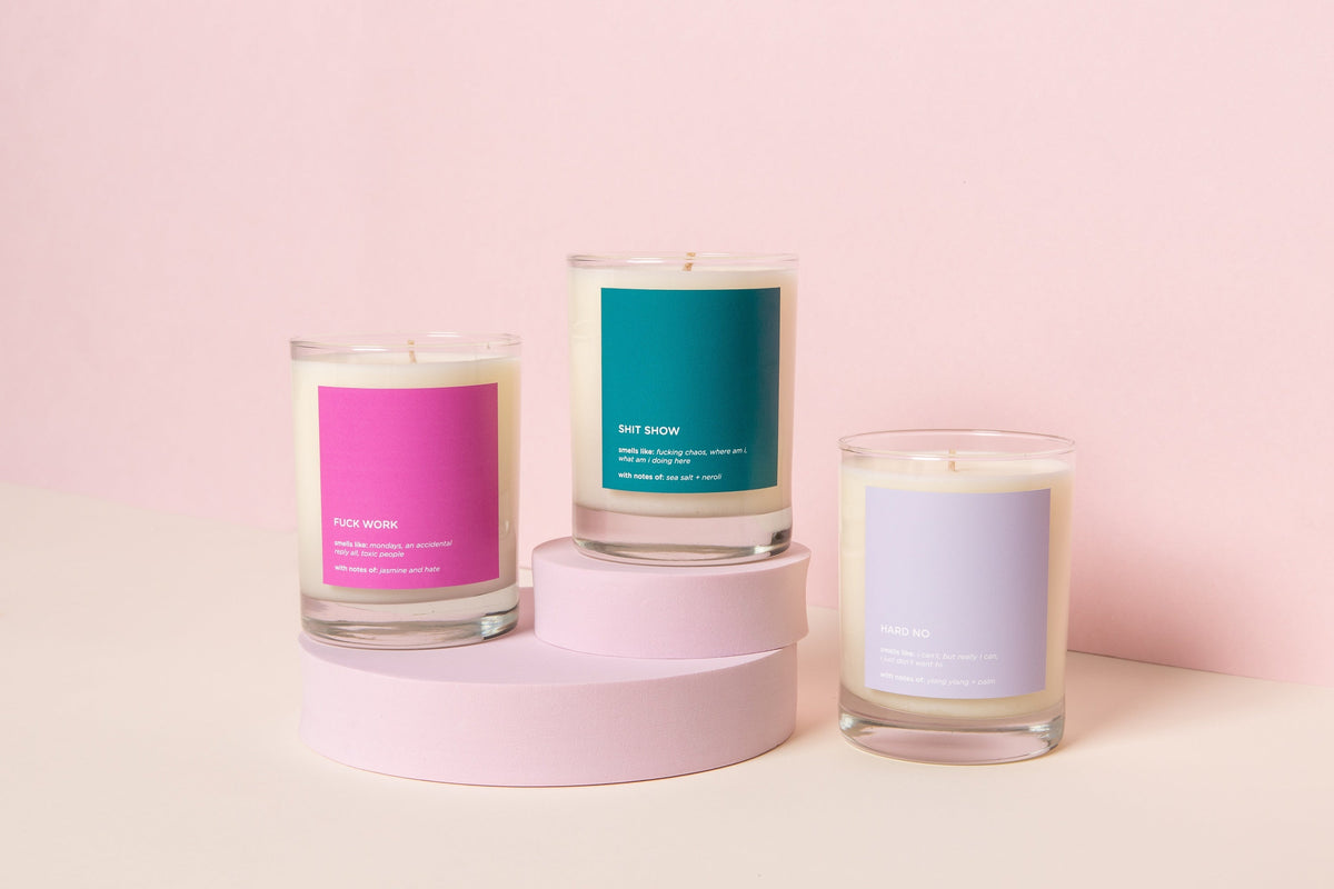 Three candles with colorful labels on a pink background