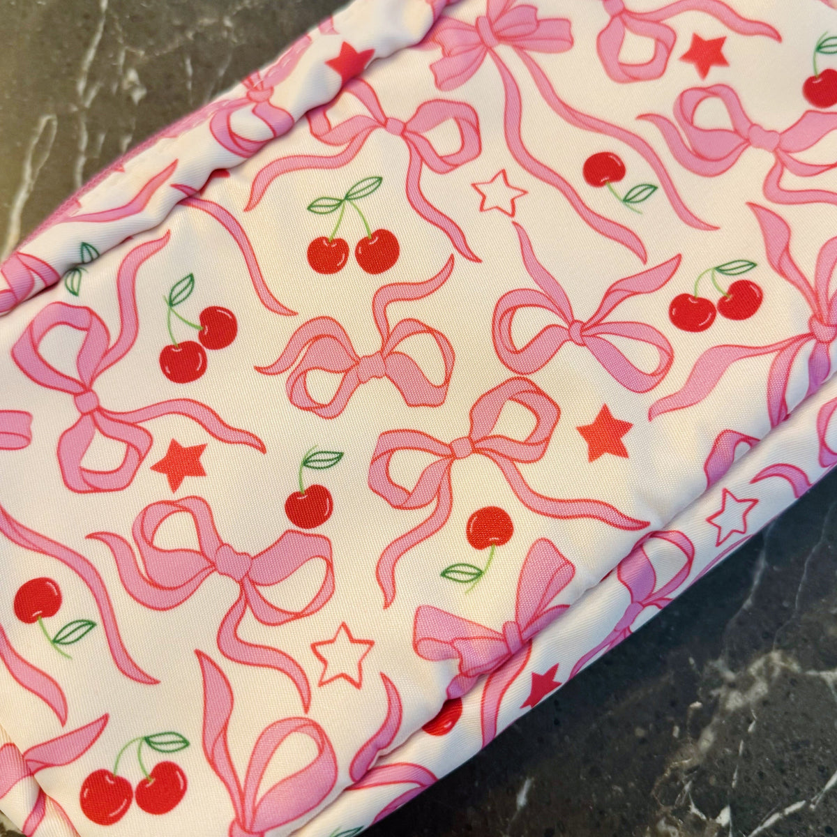 Fabric with pink bows and cherries pattern on a white background