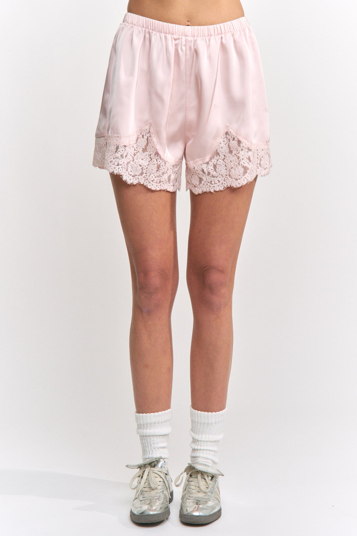 Pink lace shorts worn by a person on a white background