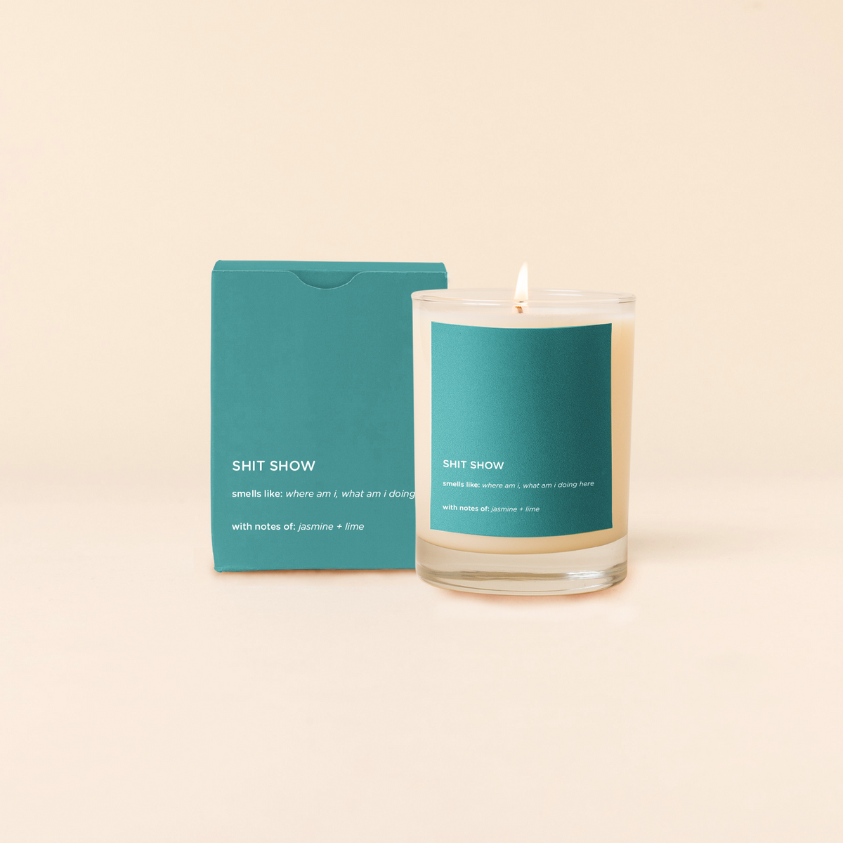 Candle with teal label and packaging on a beige background