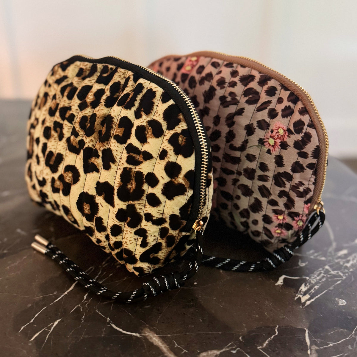 Two round pouches with leopard print design on a marble surface