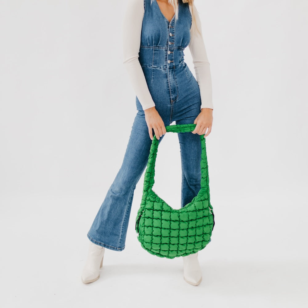 Person holding a green textured handbag against a white background