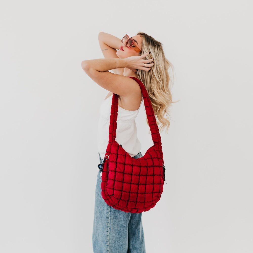 Woman holding a red plaid bag against a white background