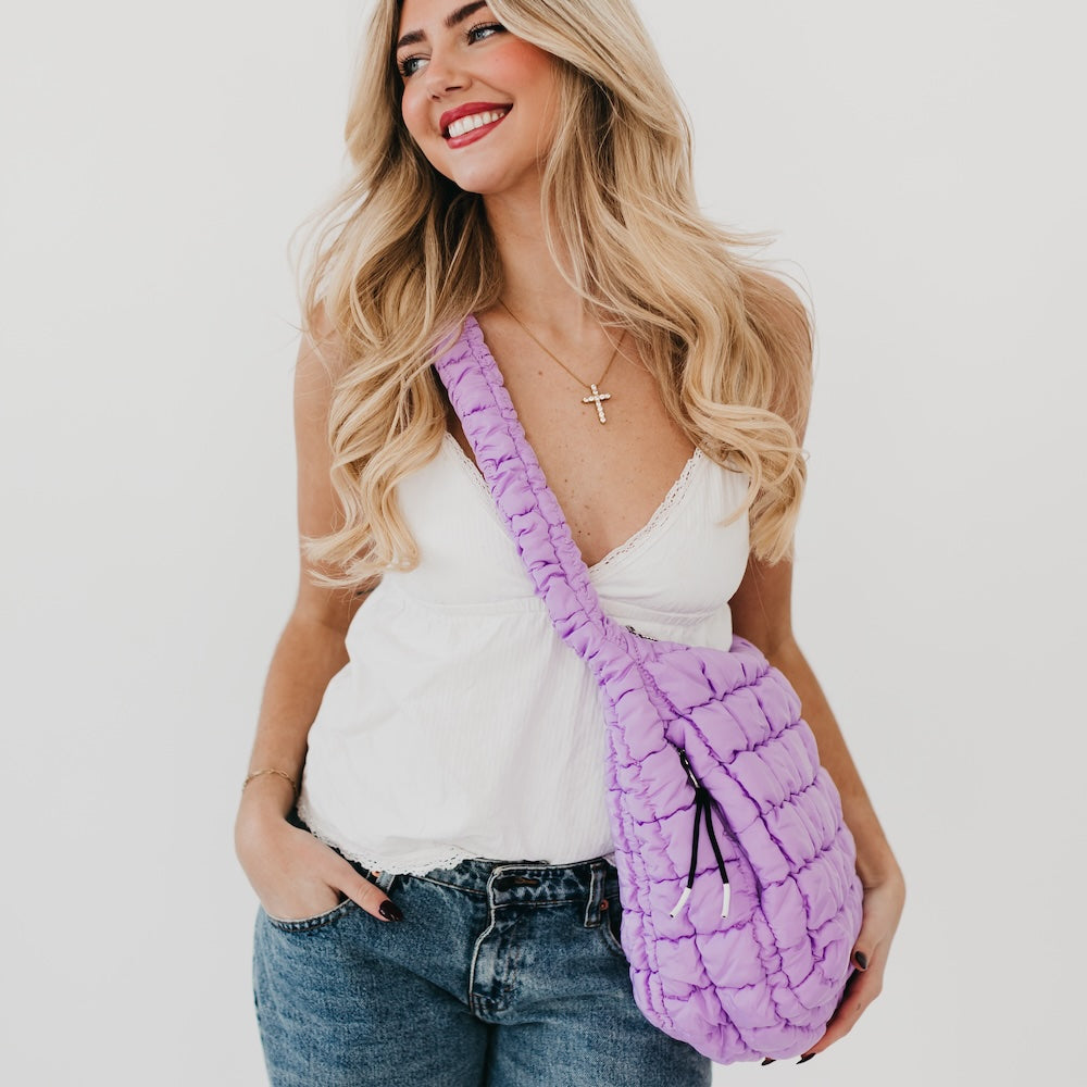 Woman holding a purple textured bag against a white background