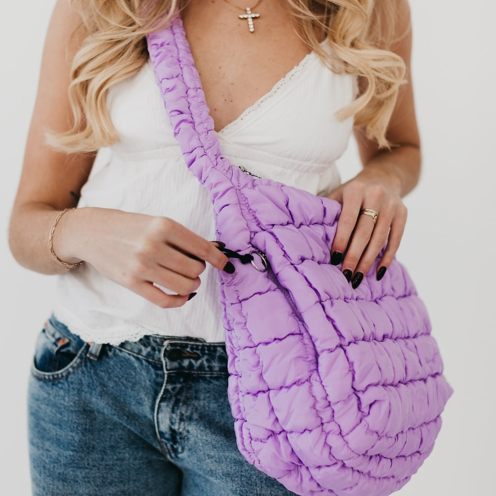 Person holding a purple textured bag with a plain background
