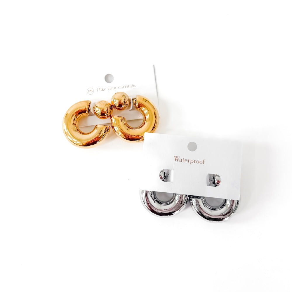 Gold and silver earrings on a white background with 'Waterproof' label.