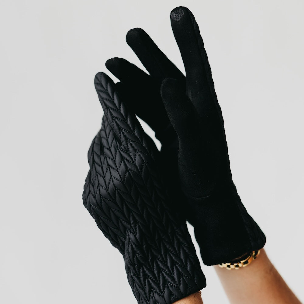 Black textured gloves on a neutral background