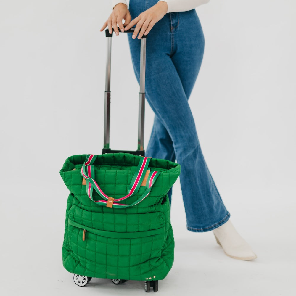 Green quilted rolling bag with a person holding it on a white background