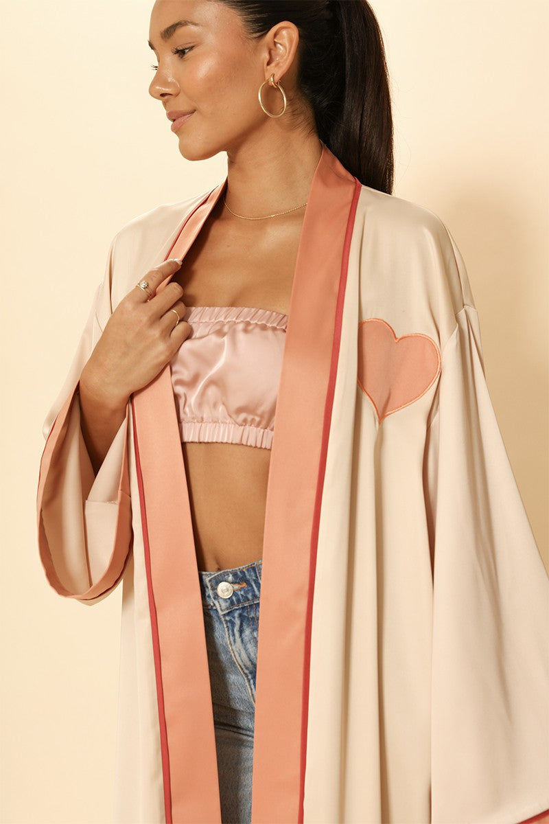 Woman wearing a light-colored kimono with pink accents on a beige background