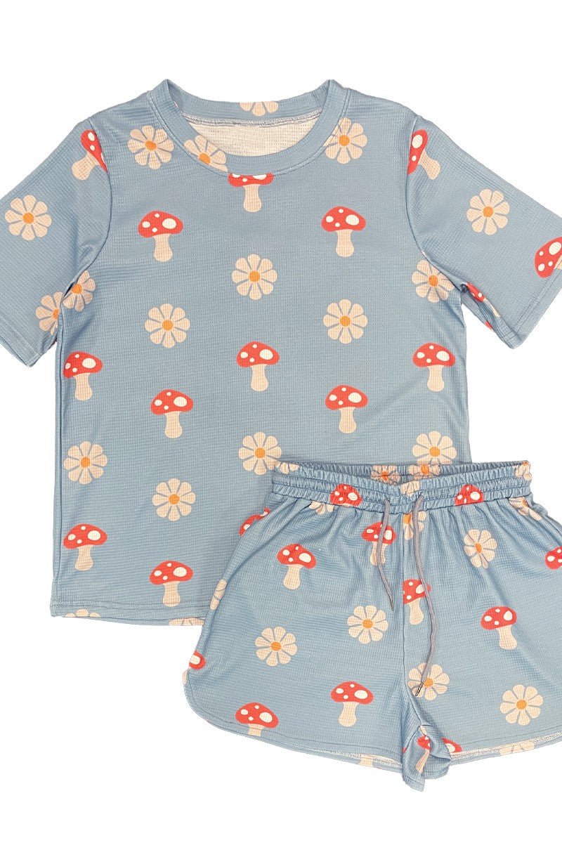 Children's set with blue top and shorts featuring mushroom and flower patterns on a white background
