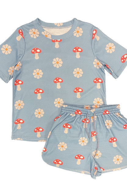 Children's set with blue top and shorts featuring mushroom and flower patterns on a white background