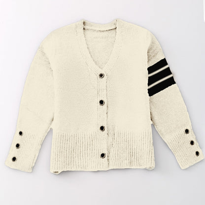 Cream-colored cardigan with black button details and striped sleeve on a light gray background