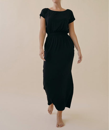 Model wearing relaxed bamboo viscose one piece jumpsuit with crop-style top and wide sleeves, in a casual setting.