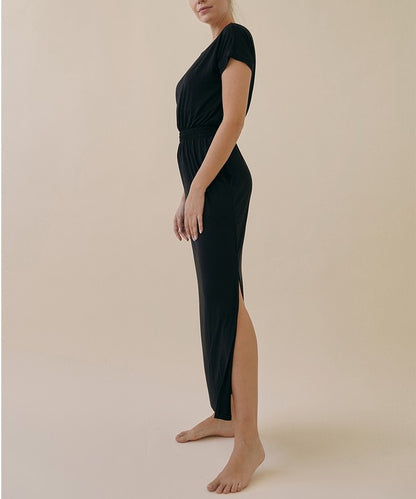 Model wearing relaxed bamboo viscose one piece jumpsuit with crop-style top and wide sleeves, in a casual setting.
