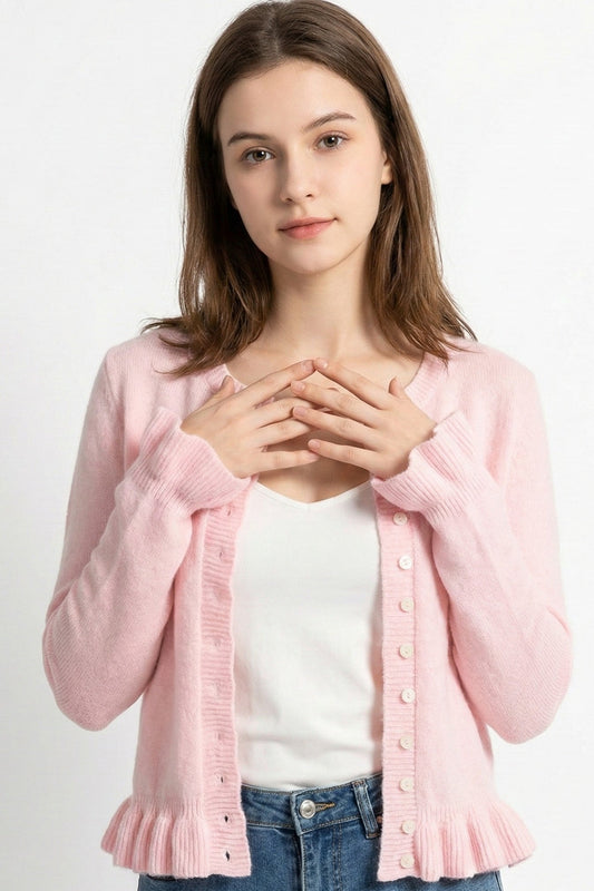 Woman wearing a pink cardigan over a white shirt on a white background