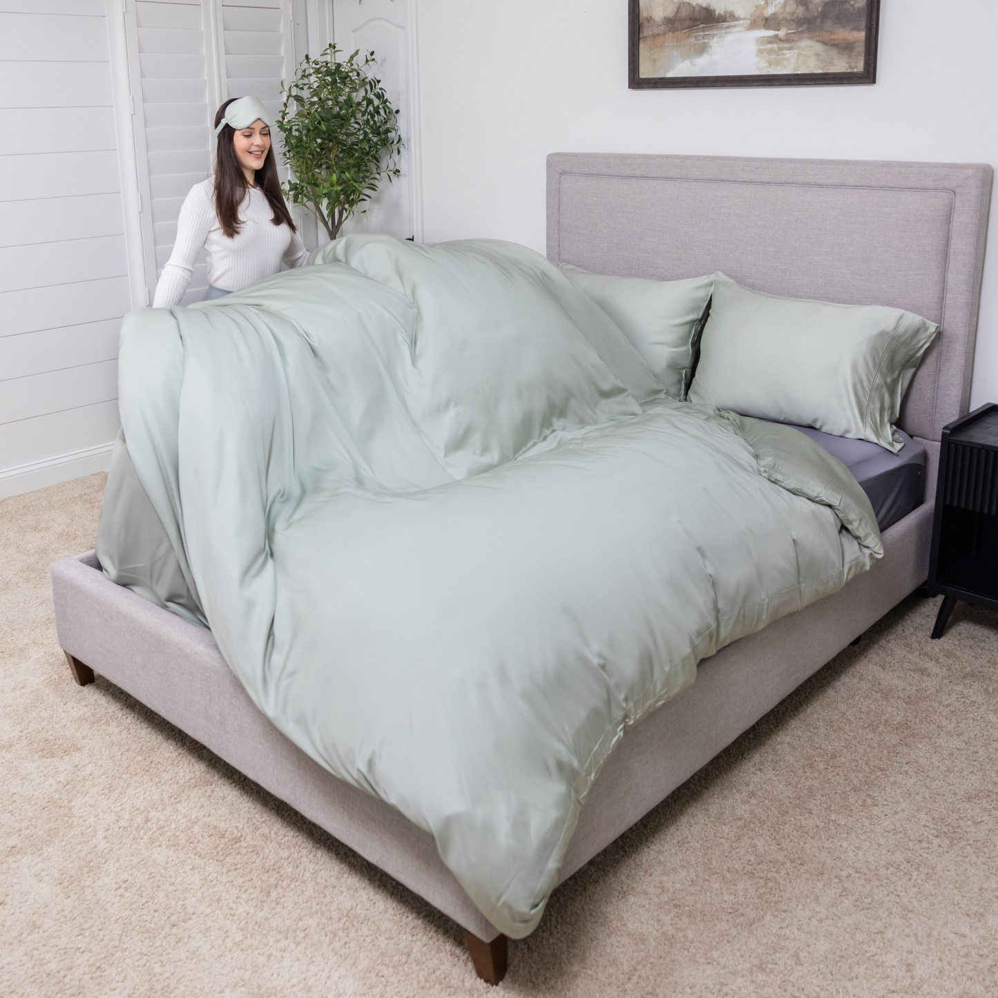 Woman standing next to a bed with light green bedding in a bedroom setting. Luxurious Organic Bamboo Duvet Cover Set