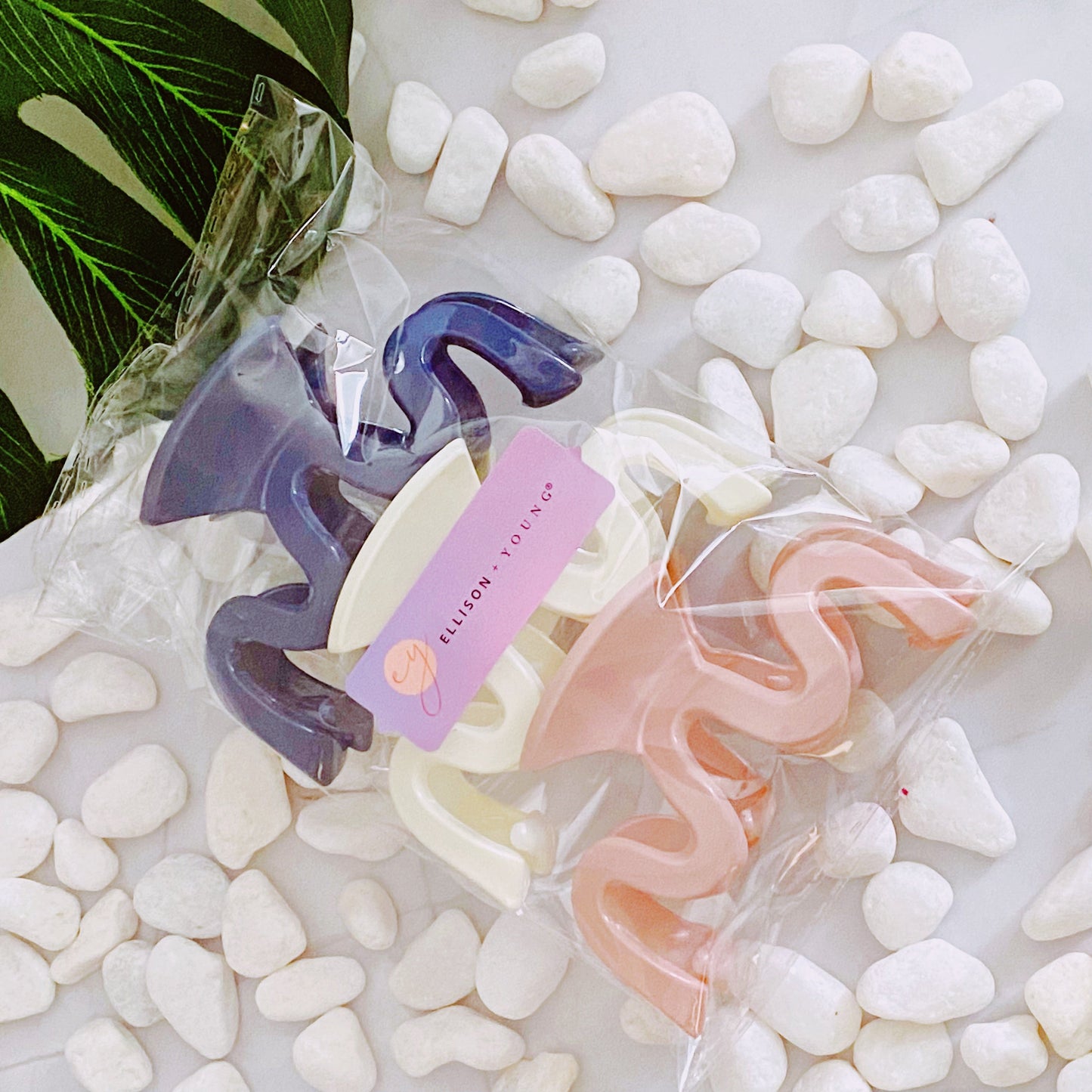 Hair accessories in clear packaging on pebbles with a brand tag visible set of 3 