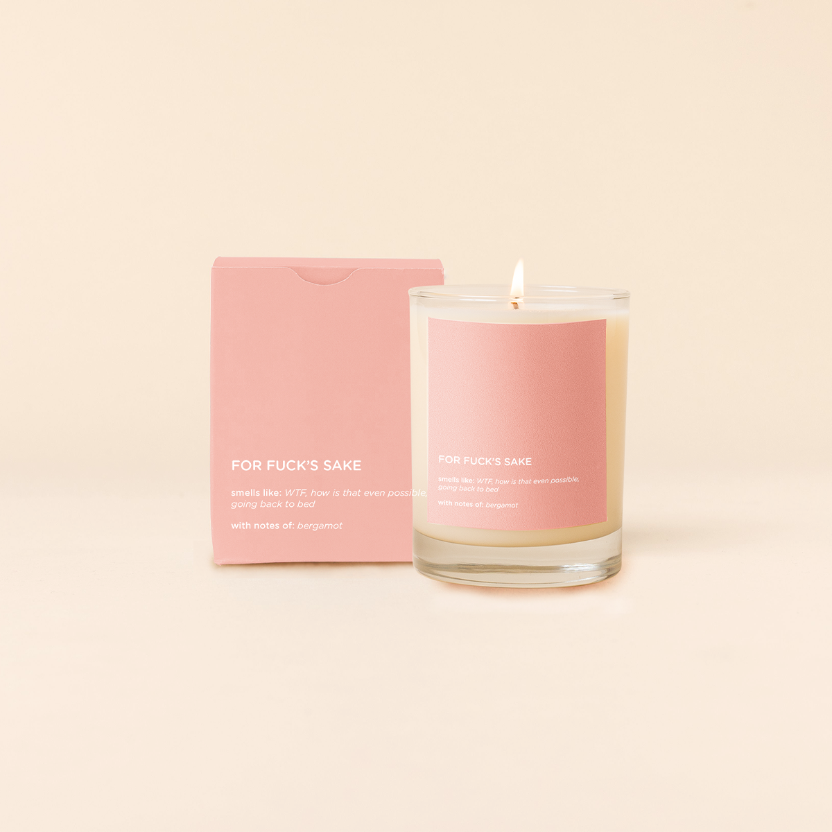 Pink candle with a matching box on a beige background