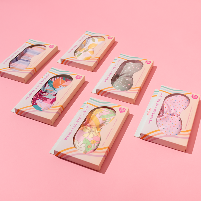 Set of colorful eye masks in packaging on a pink background