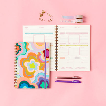 Colorful planner with a floral cover on a pink background