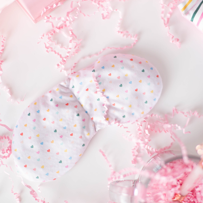 heart pattern weighted eye pillow with pink confetti on a white background
