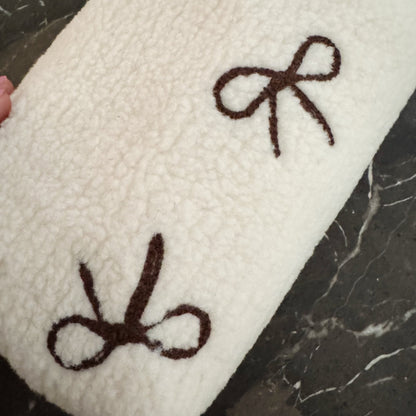 White towel with brown bows on a dark surface