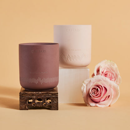 Two ceramic cups with 'CAFTARI' branding, one on a stand, the other stacked, with pink roses on a beige background.