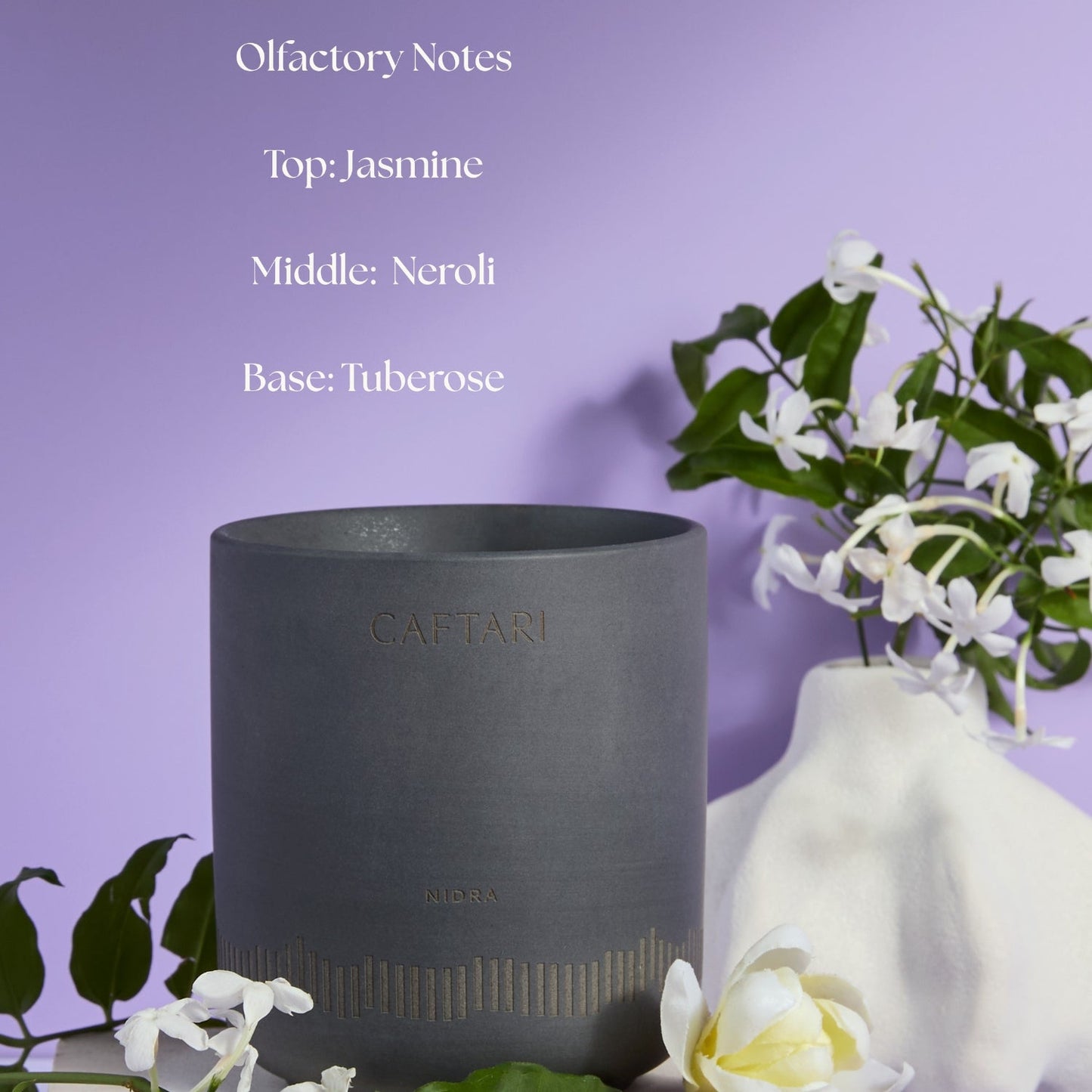 Dark gray candle with 'Agaftari' branding on a purple background with jasmine flowers.