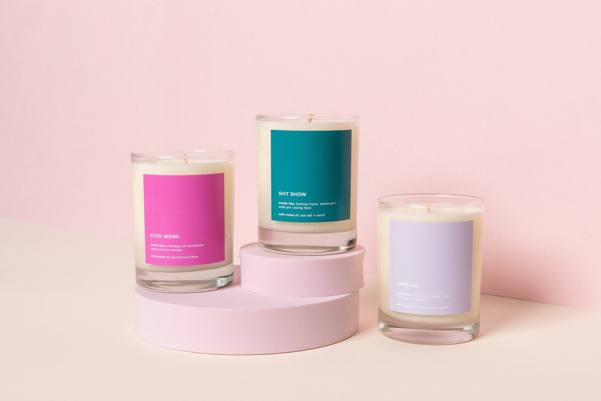 Three candles with colorful labels on a pink background