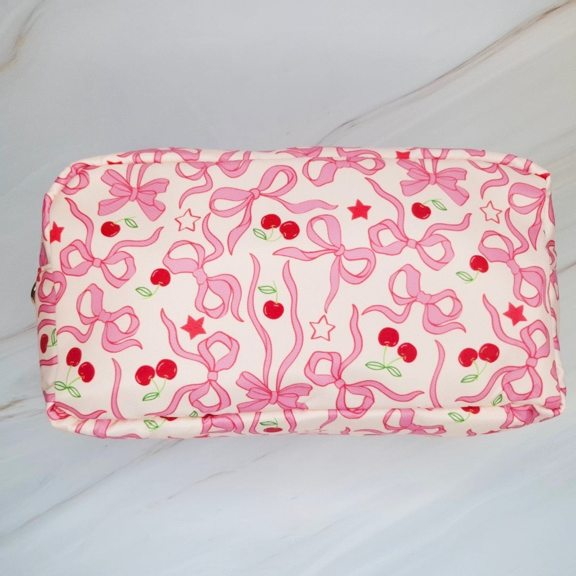 Fabric with pink bows and red cherries on a white background