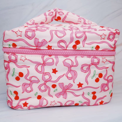 Pink and white cosmetic bag with bow and cherry pattern on a light gray background