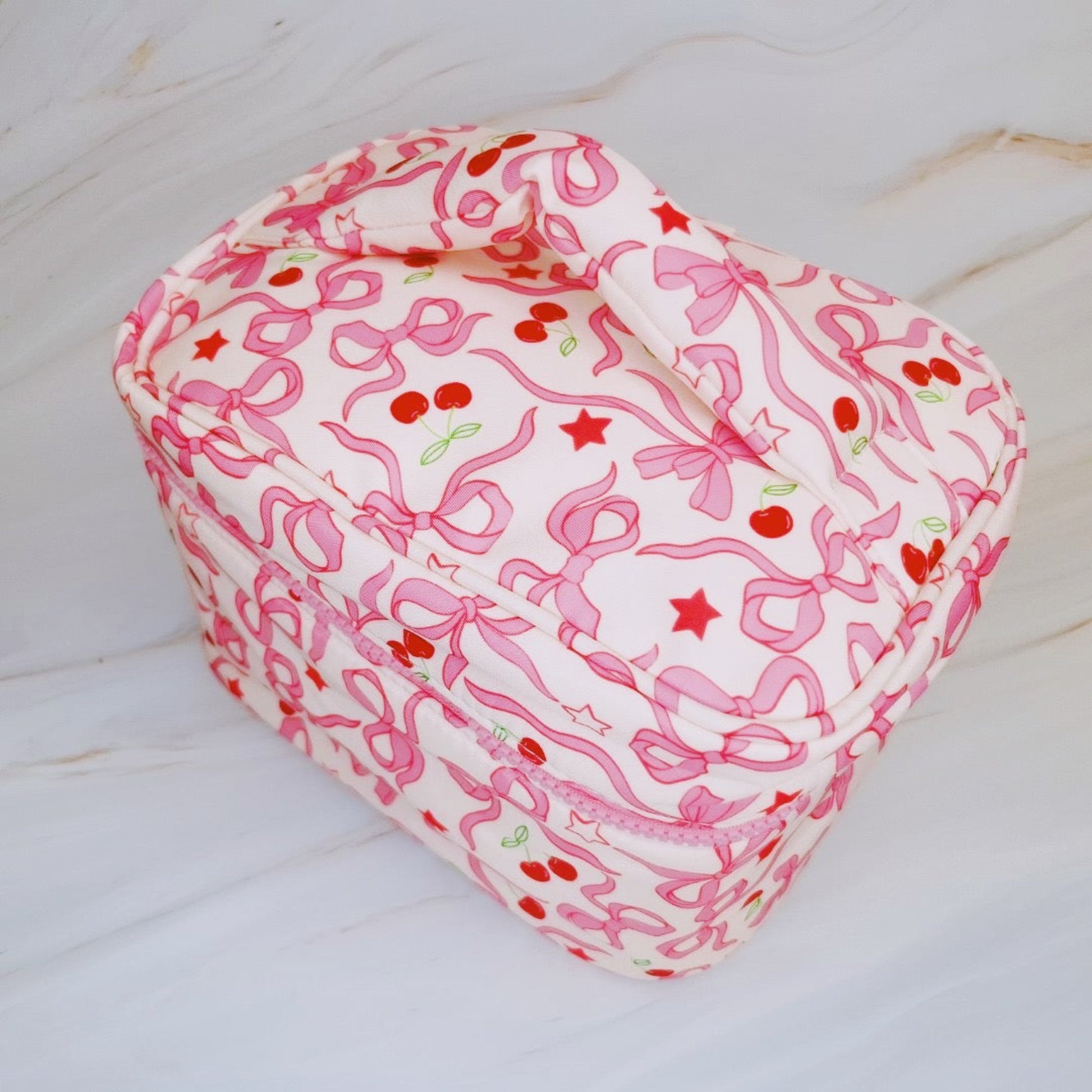 Heart-shaped pillow with pink bow pattern on a white background