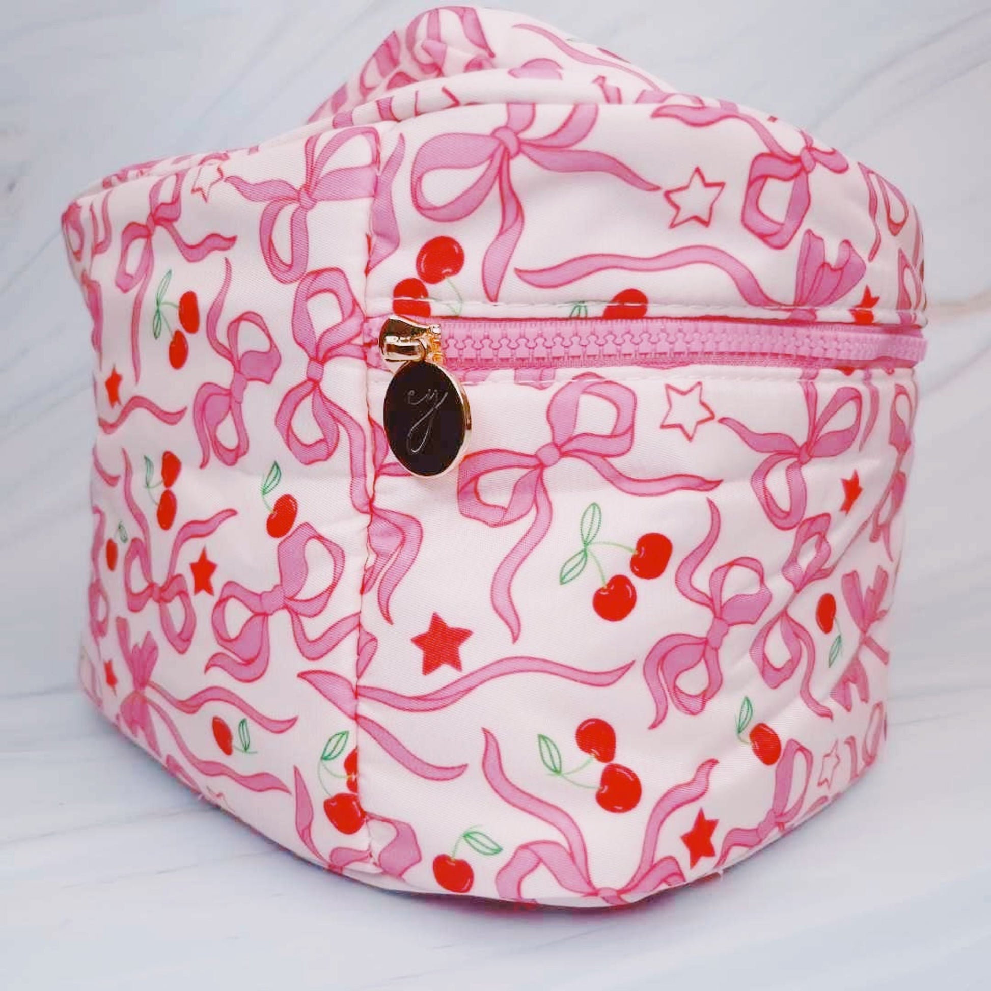 Pink and white patterned bag with cherry design on a white background