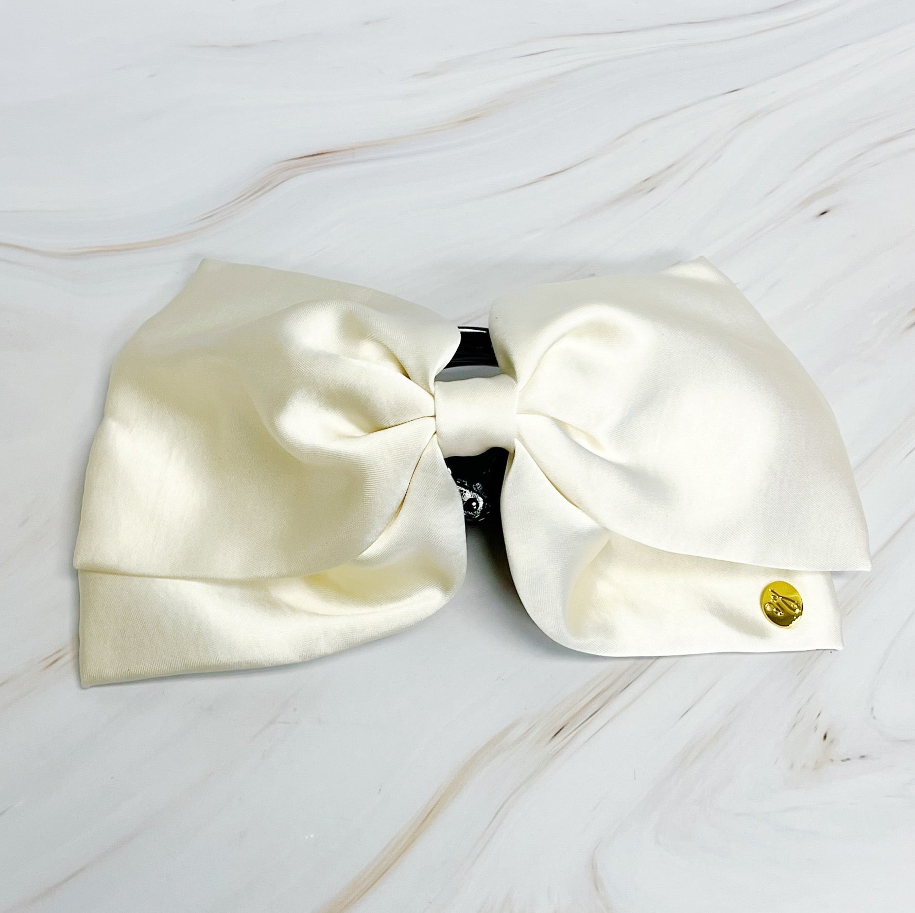 Large white bow  hair claw on a light wooden surface