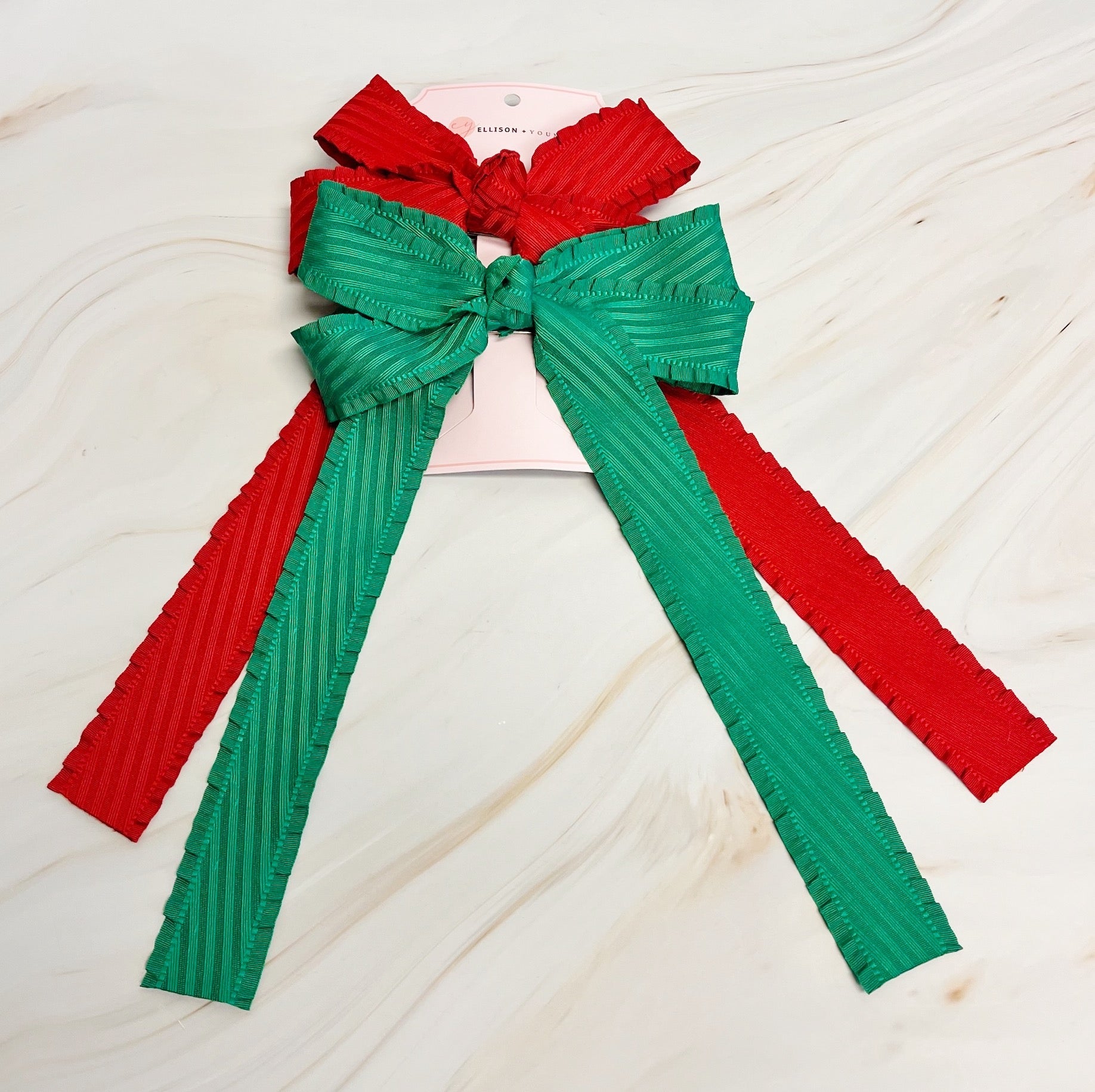 Red and green ribbed bow on a light wooden surface