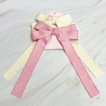 Pink and yellow decorative bow on a marble surface