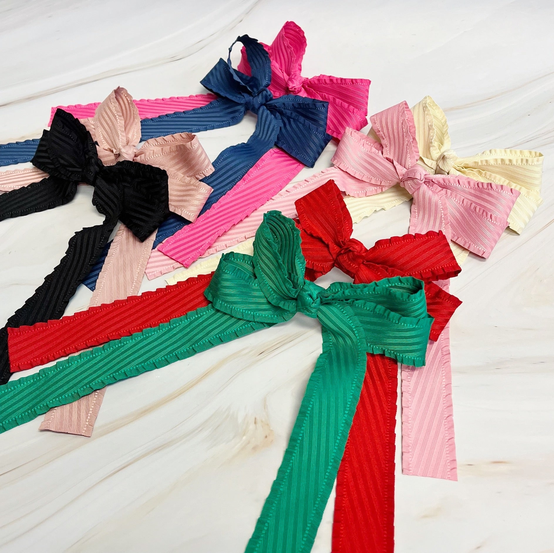 Colorful ribbed headbands with large bows on a light wooden surface