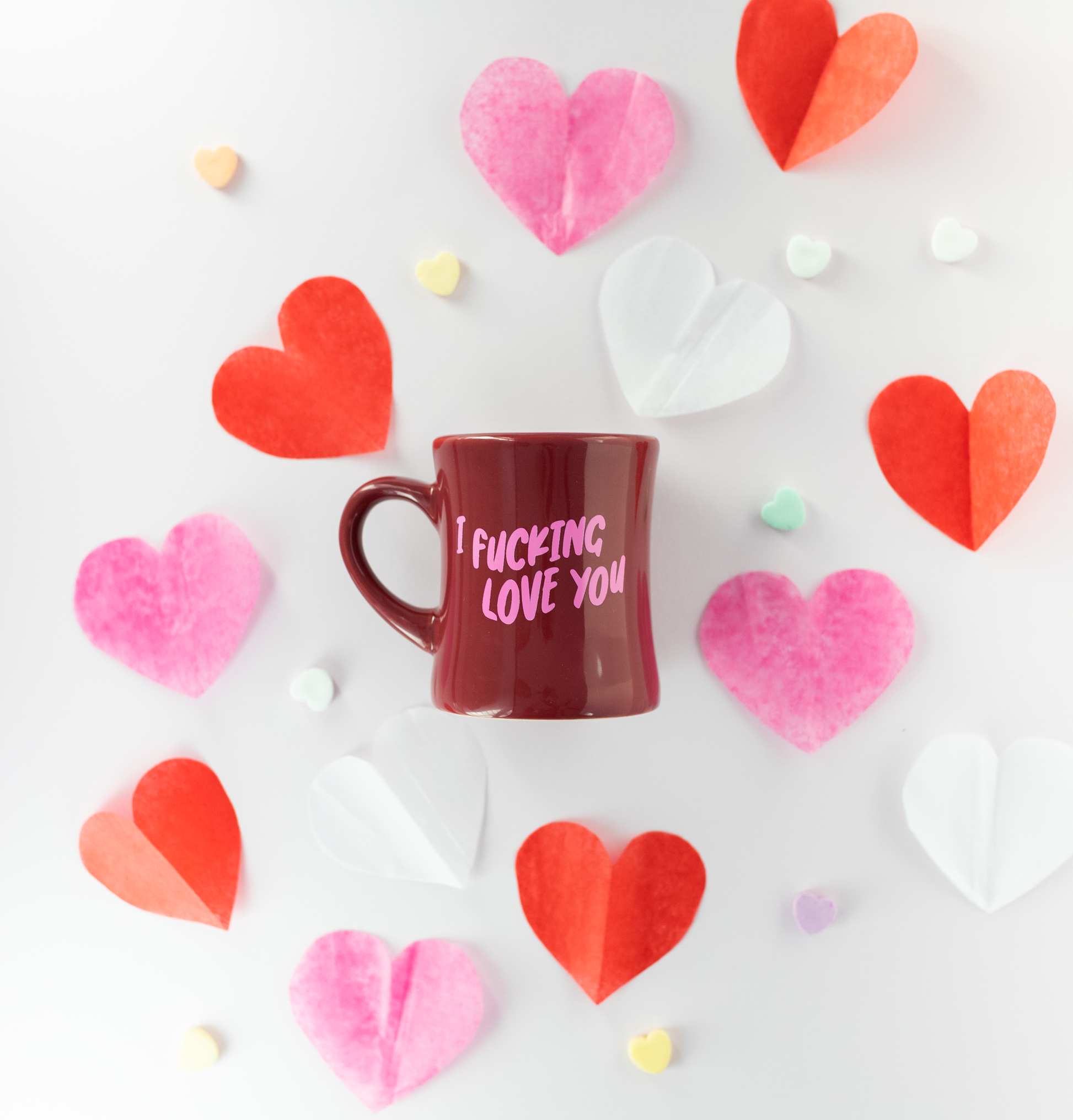 Red diner mug with 'I Fucking Love You' text on a white background with heart-shaped decorations.