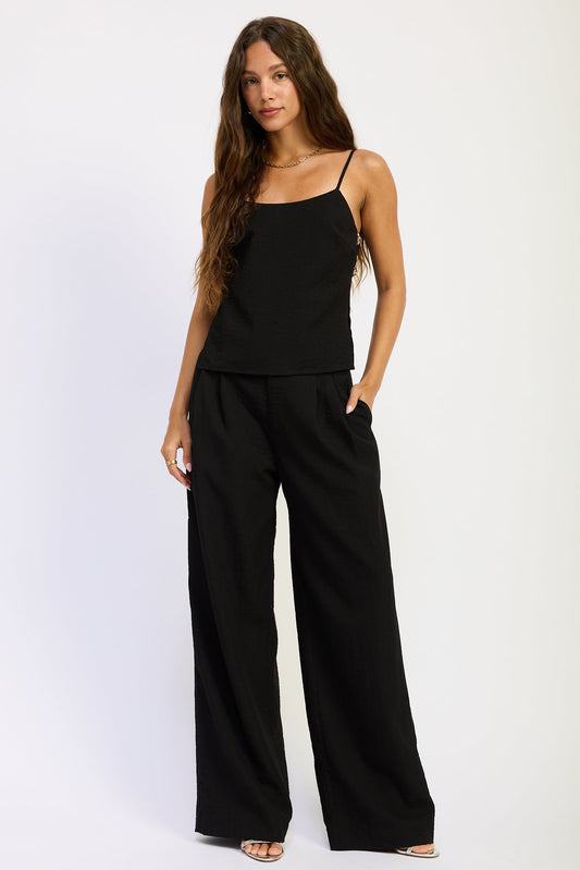 Woman wearing a black jumpsuit on a white background