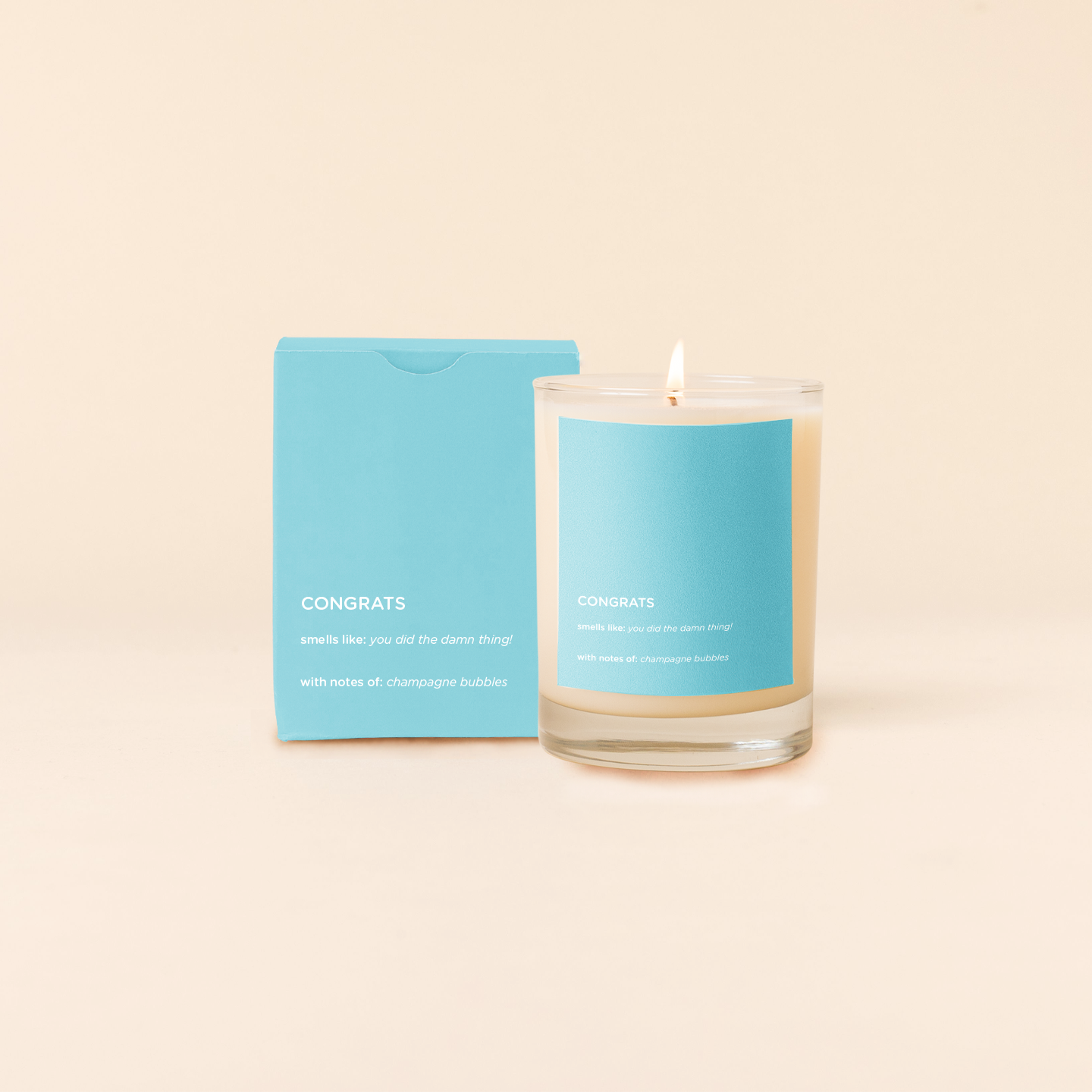 Congrats Candle with blue label and matching card on beige background