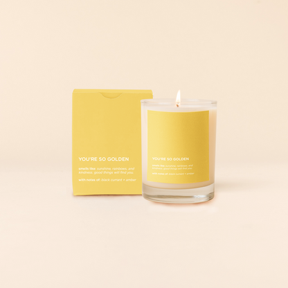 Candle and packaging with 'YOU'RE SO GOLDEN' text on a beige background