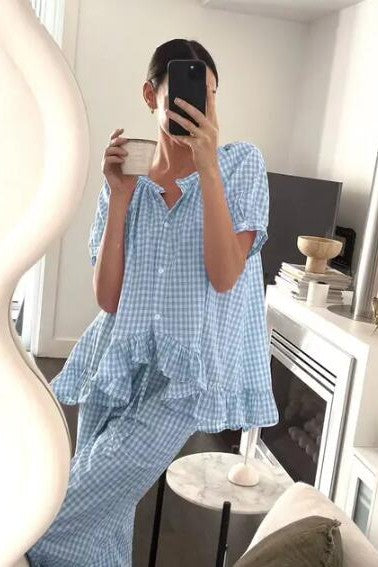 Person wearing a blue checkered outfit sitting on a couch.