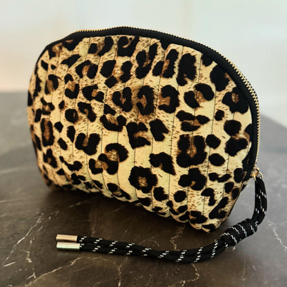 Leopard print clutch bag with a strap on a marble surface