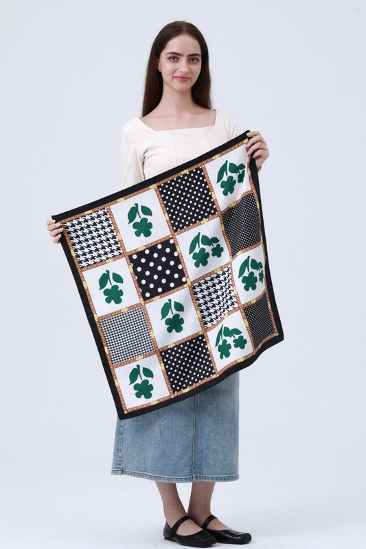 Woman holding a large scarf with a patchwork design on a white background, irish flower, black and white polka dots.