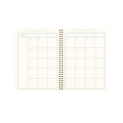 Open spiral-bound planner with grid layout on white background