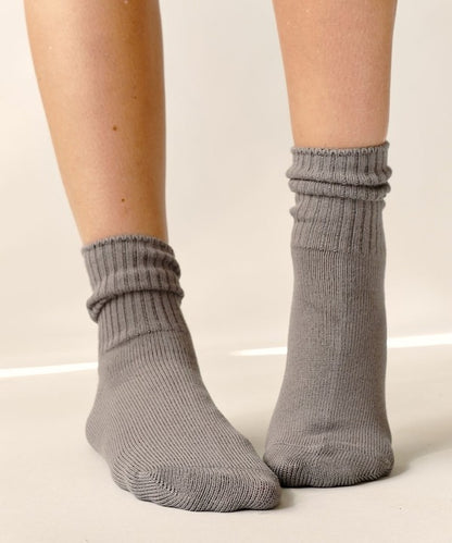One size organic bamboo socks in neutral colors: grey, olive, taupe, and white, folded and displayed on soft surface.