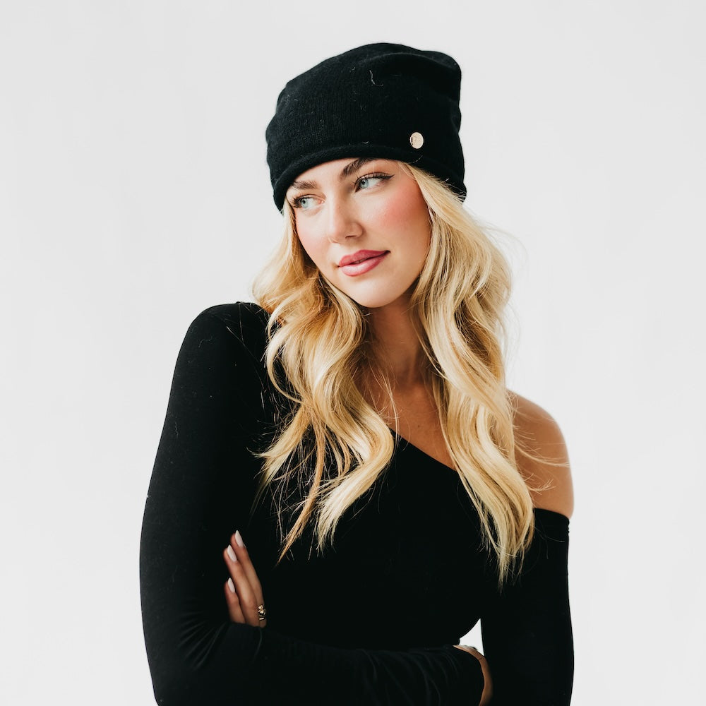 Woman wearing a black knit cap against a white background